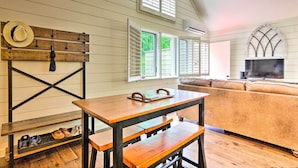 A cozy living room with a wooden table, benches, a sofa, and a TV. - Elegant Sapphire Valley Studio w/ Resort Amenities (Sapphire)