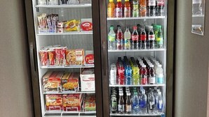 Two beverage vending machines labeled "really cold" and "cold," stocked with various drinks and snacks. - Home2 Suites BY Hilton Hinesville (HINESVILLE)