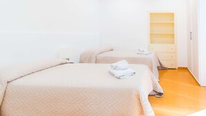 A hotel room with two beds, a small bedside table, a built-in shelf, and a wardrobe. - Residence Le Axidie Sure Hotel Collection by BW (Vico Equense)