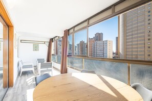 A modern room with a large window, a round table, and white chairs. - Waldorff 4-A (Benidorm)