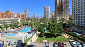 A high-rise hotel with a rooftop pool, surrounded by palm trees and other buildings. - Waldorff 4-A (Benidorm)