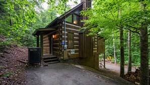 Ein rustikales Holzhaus mit Veranda und kleinem Eingang.