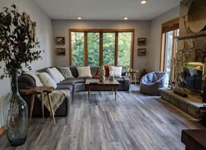 Un salon moderne avec un canapé d’angle, une table basse et une cheminée.
