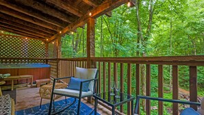 Una terraza de madera con mobiliario exterior, una mesa y sillas.