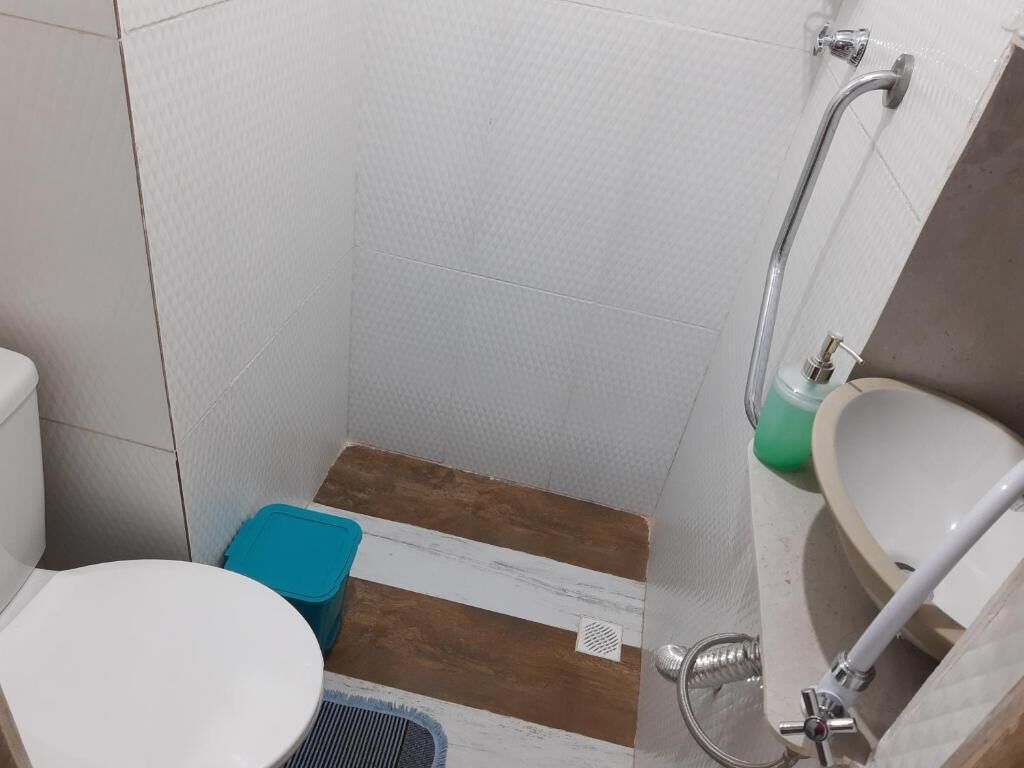 A small bathroom with a toilet, a shower, and a sink.
