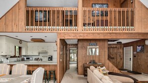 Amplio espacio tipo loft con un sofá grande, una mesa de comedor y una zona de cocina.