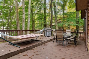 A wooden deck with a hammock, grill, and outdoor table and chairs. - Lakefront Poconos,   Early check in late check out during winter months. (Gouldsboro)