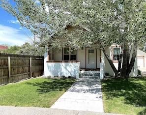 Welcome to a charming single-story home with a cozy front porch and beautifully manicured lawn.