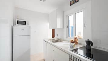 Enjoy cooking in this well-equipped kitchen with a microwave, induction cooktop, and stainless steel sink.