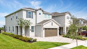 A two-story residential building with a garage, a driveway, and a well-maintained lawn. - Trendy 5BR Villa with Private Pool Near Disney (Kissimmee)