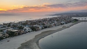 A coastal cityscape with a beach, buildings, and a pier. - Steps to the Sand + Patio Lounging | Sunset Water Views | Bay View 3 (San Diego)