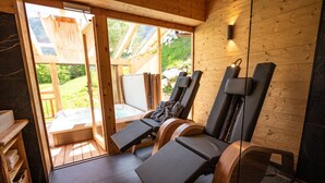 Un sauna aux murs en bois et une porte en verre donnant sur un espace extérieur.