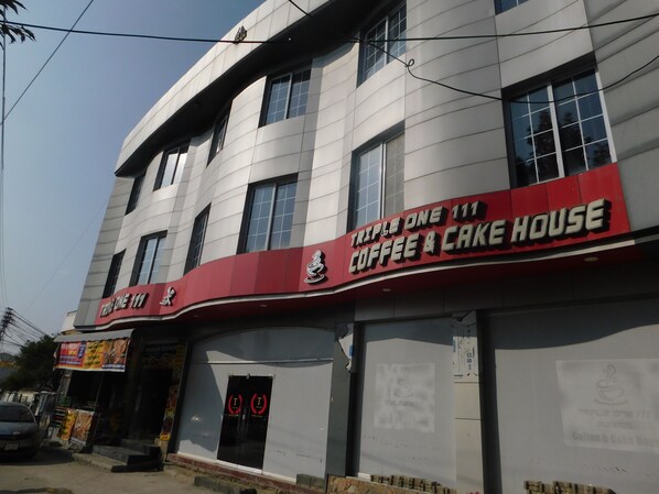 A building with a sign for "Triple One 111 Coffee & Cake House". - Triple One Hotel Suites (Abbottabad)