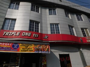 A building with a red and white facade, featuring a sign for 'TRIPLE ONE 111'. - Triple One Hotel Suites (Abbottabad)