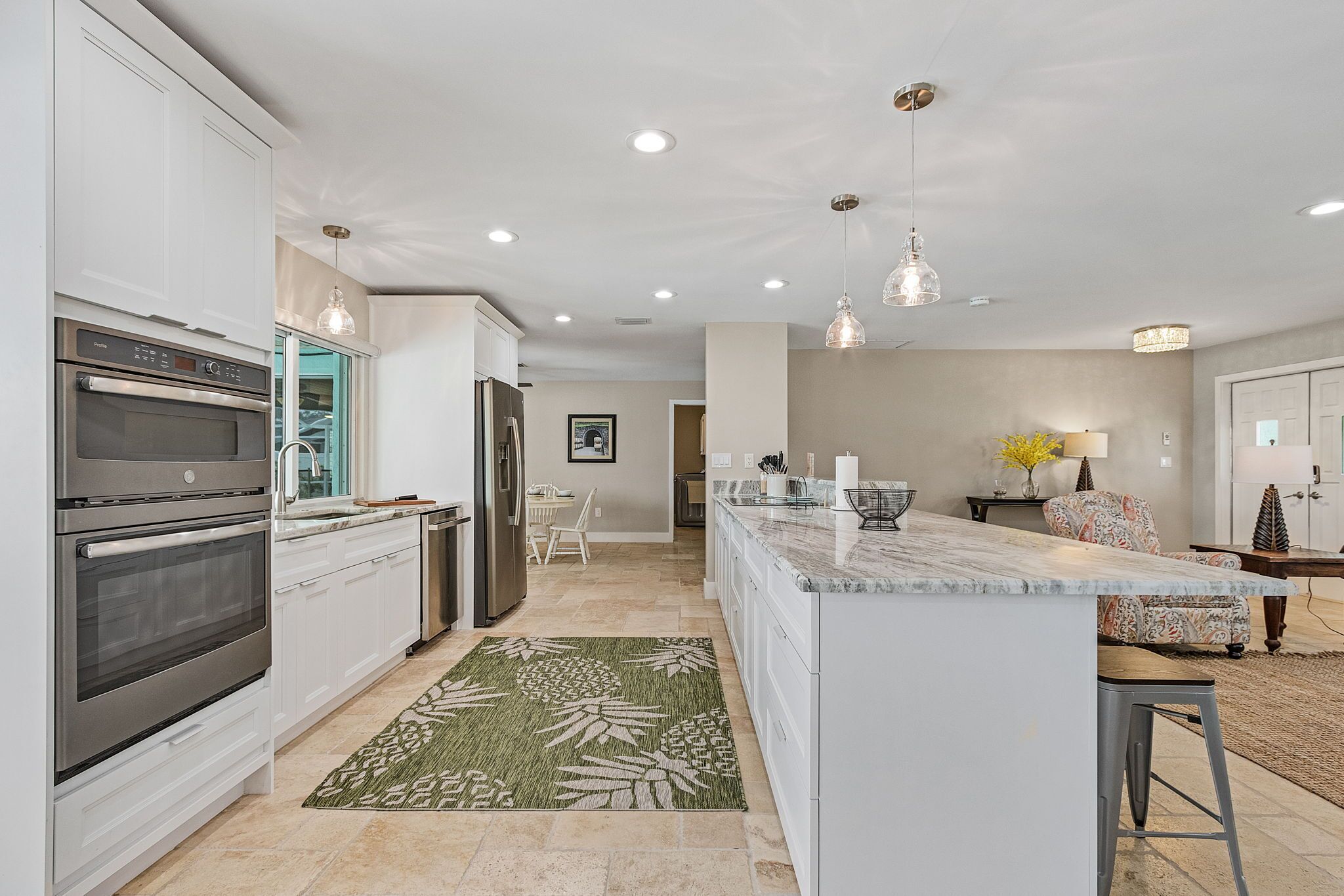 A modern kitchen with white cabinetry, stainless steel appliances, and a central island.