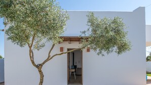 A modern building with a white exterior, a wooden pergola, and a tree in front. - Holiday Home "Casa Trafalmar" with Pool, Wi-Fi, Garden and Terrace (Zahora)