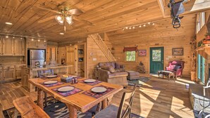 A wooden cabin interior with a dining area, kitchen, and living space. - Dreamy Ellijay Resort Cabin w/ Game Room & Decks! (Ellijay)