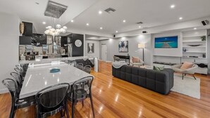 A modern living space with a dining area, kitchen, and seating area. - StayCentral - Moonee Ponds Penthouse - Mount Alexander Rd, Moonee Ponds - 3 Bedrooms, 4 Beds, 2 Bathrooms, 2 secure undercover parking spot. (Moonee Ponds)