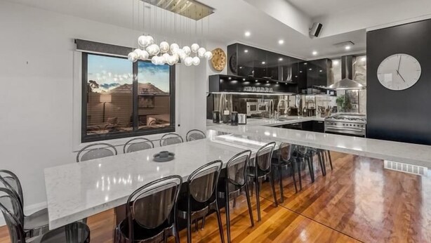 A modern kitchen with a central island, stainless steel appliances, and a large window with a view. - StayCentral - Moonee Ponds Penthouse - Mount Alexander Rd, Moonee Ponds - 3 Bedrooms, 4 Beds, 2 Bathrooms, 2 secure undercover parking spot. (Moonee Ponds)