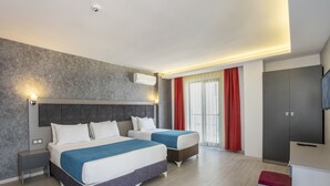 Une chambre d’hôtel moderne équipée de deux lits, d’un téléviseur à écran plat et d’une armoire.