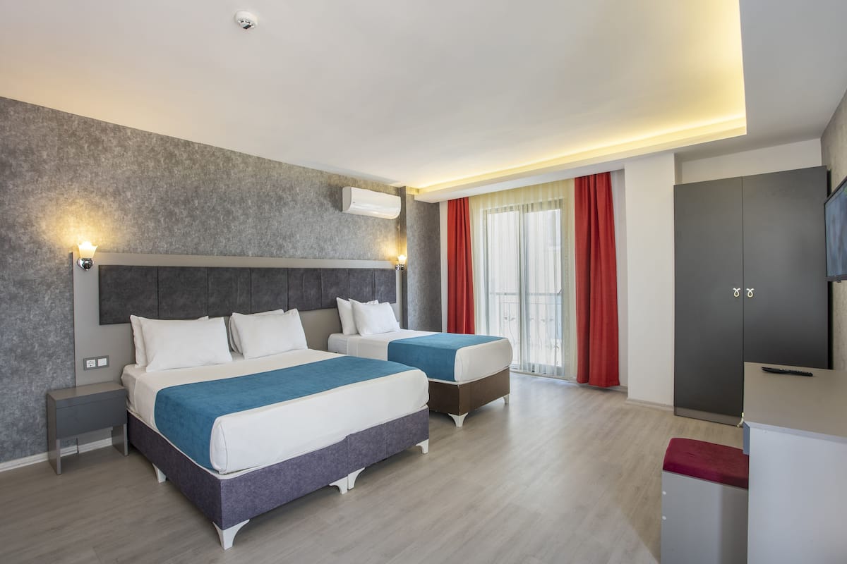 Een moderne hotelkamer met twee bedden, een flatscreen-tv en een kledingkast.