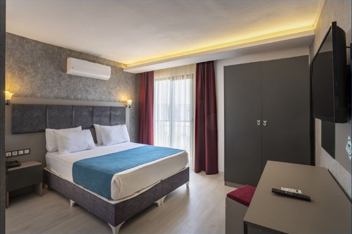 Une chambre d’hôtel moderne équipée d’un lit, d’une table de chevet et d’un téléviseur.