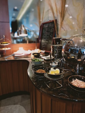 A restaurant counter with various dishes and a coffee machine.