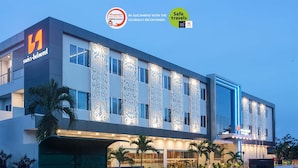 Ein modernes Hotel mit markantem Logo, dekorativer Fassade und beleuchtetem Eingang.