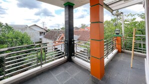 A balcony with a view of residential buildings and greenery. - Homestay Jogja Jakal 3 Dekat UGM by Simply Homy (Ngaglik)