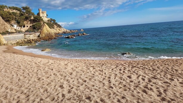A beach with a castle on a cliff, clear skies, and calm sea. - KESITO FAMILY APARTAMENT BJ.-3ª (Lloret de Mar)