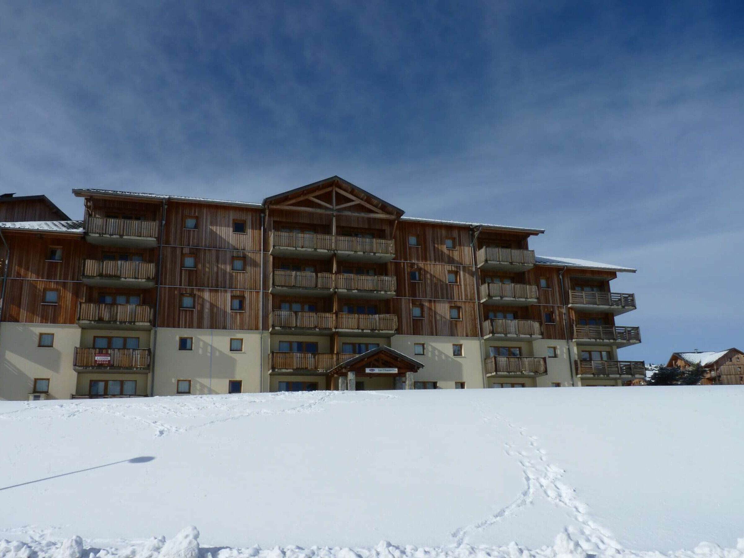 A multi-story wooden building with balconies, likely a hotel or resort.