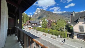 A balcony with a view of a mountain and a town. - Family duplex in village center, pets allowed (Samoëns)