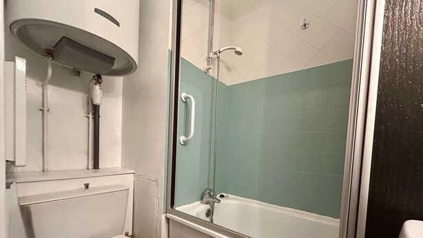 A bathroom with a toilet, sink, and shower area.