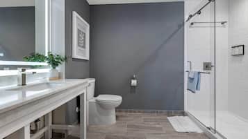 Une salle de bain moderne avec un meuble-lavabo blanc, des toilettes et une douche à parois de verre.