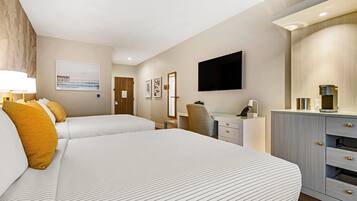 Habitación de hotel con dos camas, un escritorio, una silla, un televisor de pantalla plana y un minibar.