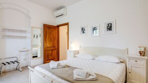 A bedroom with a bed, bedside tables, a wardrobe, a mirror, and wall-mounted pictures. - GuestHost - Cozy 50 sqm apartment, able to accommodate up to 5 people, located on the ground floor (1 low step to access to it) of a farmhouse surrounded by greenery, a short distance from the center of Florence. The property is located a few meters from (Firenze)