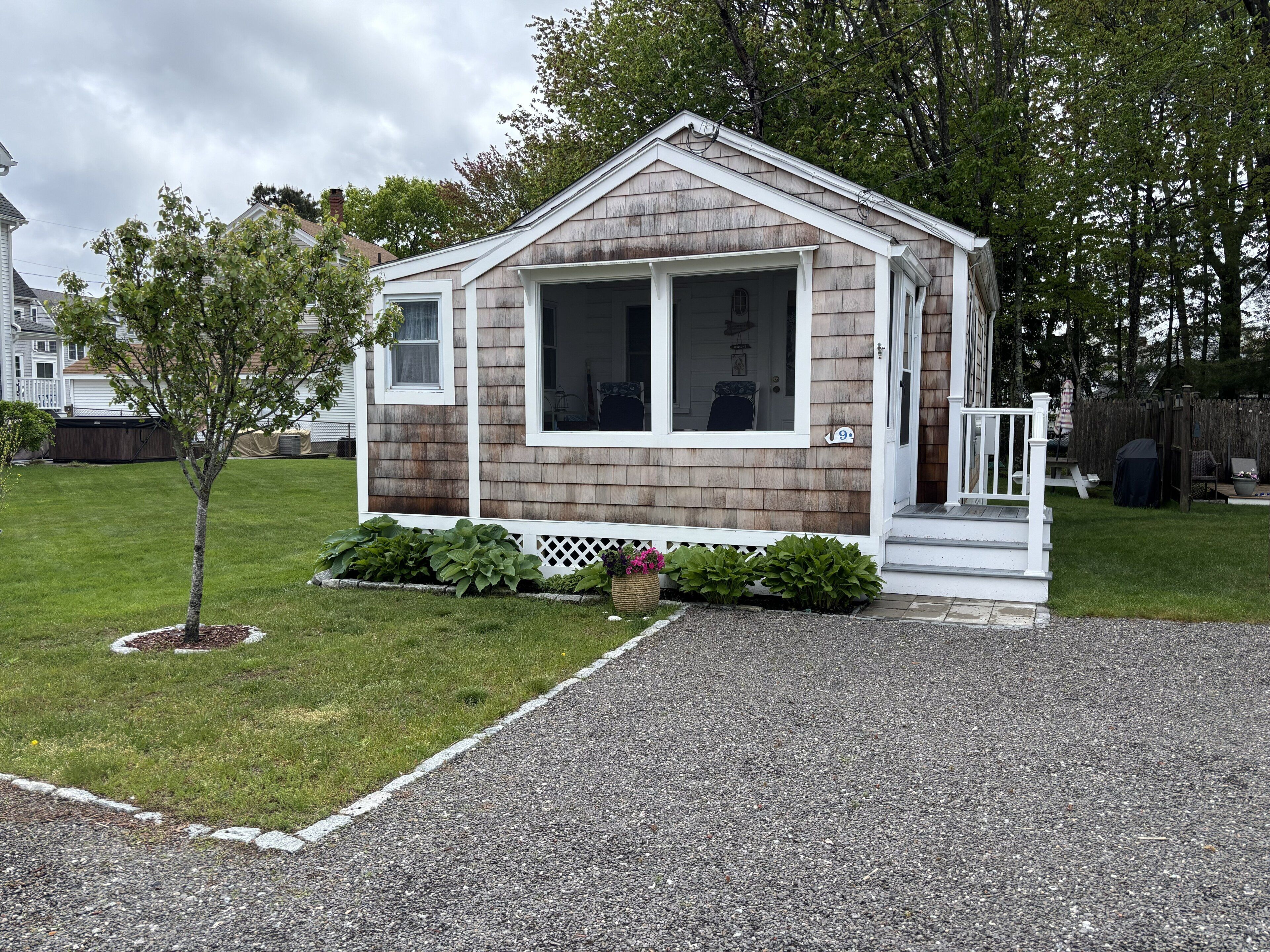 A small, single-story house with a front porch, a garage, and a well-maintained lawn.