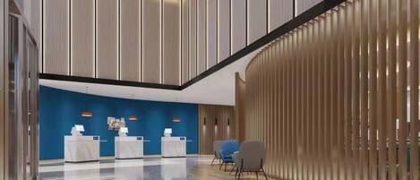 A modern lobby with a blue accent wall, a reception desk, and a seating area.