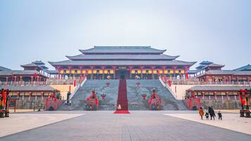 Ein traditionelles chinesisches Gebäude mit einer zentralen Treppe, roten Laternen und einem mit Fliesen belegten Innenhof.