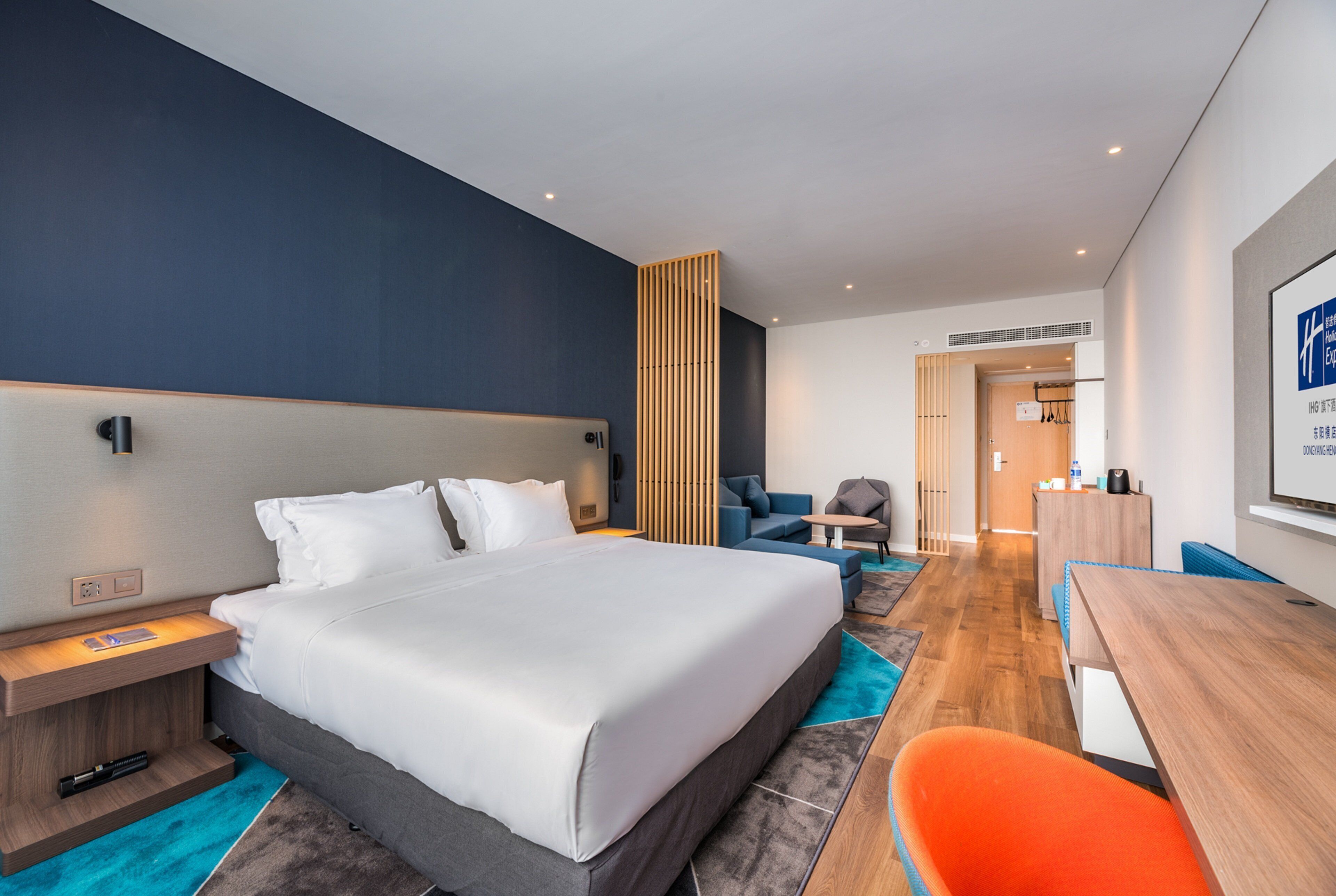 Habitació d'hotel moderna amb un llit gran, un escriptori i una zona de seients.