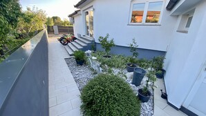 A residential property with a paved patio, a small garden with potted plants, and a bicycle parked near the entrance. - Stunning 3-bedroom Villa With a Private Pool-pula (Pula)