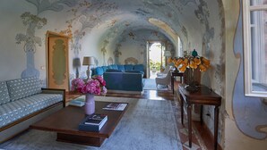 A spacious living room with a sofa, coffee table, and a view into another room. - Villa Torre di Terzolan With Pool and Jacuzzi (Verona)
