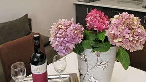 A bottle of Zlantan Cuvée wine, two wine glasses, and a silver vase with pink hydrangeas on a tray. - A1 - Modern apt With Balcony, sea View & Parking (Sucuraj)