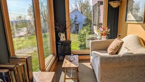 Uma sala de estar aconchegante com um sofá, uma pequena mesa de madeira e uma estante.