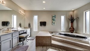 A modern bathroom with a large mirror, vanity, and a bathtub. - Fountain Hills Gem With Pool and Great Views! (Fountain Hills)