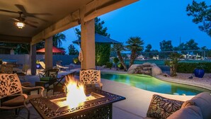 An outdoor patio with a fire pit, seating, and a swimming pool. - Spectacular Golf Course Home With Pool and Views! (Gilbert)