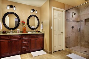 Double vanity and spacious shower area with glass door.