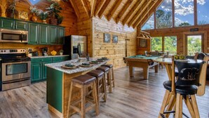 A wooden cabin interior with a kitchen, bar area, and pool table. - City View Chalet, City View Chalet, Pool Table, Hot Tub, Free Attraction Tickets (Gatlinburg)
