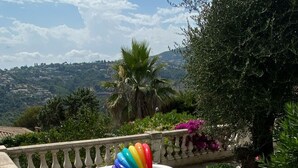 Eine Terrasse mit einem runden Tisch und Stühlen, umgeben von einer Steinbalustrade.