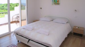 A bedroom with a bed, a bedside table, a chair, and a painting on the wall. - A2 - Modern apt With Balcony, sea View & Parking (Sucuraj)